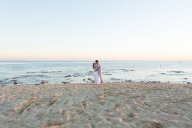 Çift kucaklayan ve birbirlerine karşı okyanus plaj öpüşme