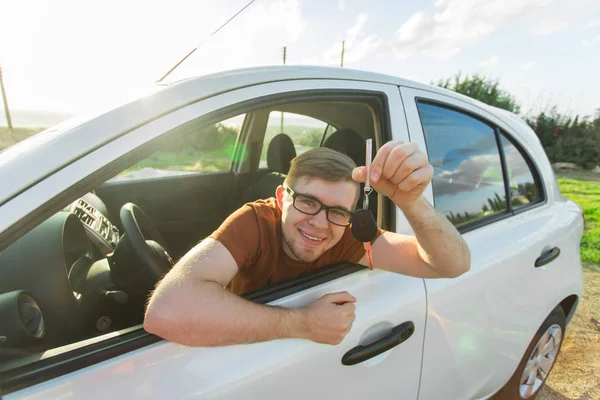 Šťastný muž, ukazující klíč jeho nové auto — Stock fotografie