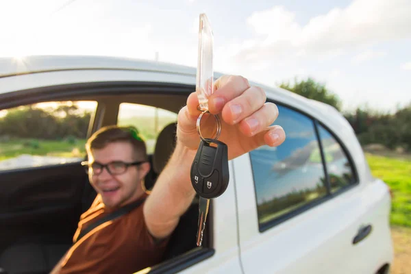 Šťastný muž, ukazující klíč jeho nové auto — Stock fotografie