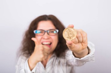 İş kadını altın Bitcoin sikke ve jest Yaşasın gösterilen gülüyor. Sanal para kavramı. Cryptocurrency
