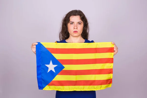 肖像的严重加泰罗尼亚女人与 estelada 标志。来自西班牙的加泰罗尼亚地区分离的全民投票。民主独立概念. — 图库照片