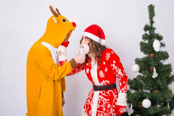 Giovane donna felice in cappello di Babbo Natale e uomo in costume di carnevale di cervi. Divertimento, vacanza, scherzo e concetto di Natale — Foto Stock