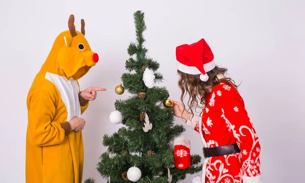 산타 클로스 모자와 사슴의 카니발 의상에서 남자에 재미 있는 젊은 여자. 재미, 휴일, 농담 및 크리스마스 개념 — 스톡 사진