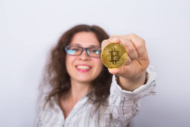 Mutlu kadın altın Bitcoin para gösteriliyor. Sanal para kavramı. Cryptocurrency