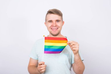 Gökkuşağı bayrakları tutan el ile eğlenceli erkek ayakta. Cinsel azınlık ve Lgbt kavramı