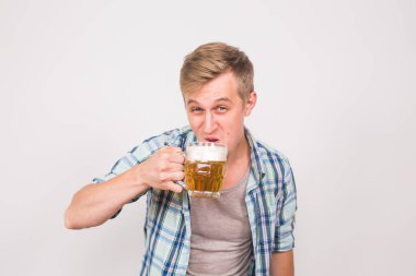 Adam bira içiyor. Beyaz arka plan üzerinde Lager bira içme yakışıklı genç adam