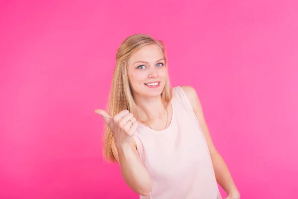 Feliz joven mujer dando pulgares hacia arriba sobre fondo rosa — Foto de Stock