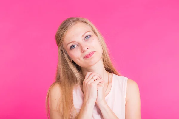 Mooie jonge vrouw glimlachen tegen een roze achtergrond. — Stockfoto