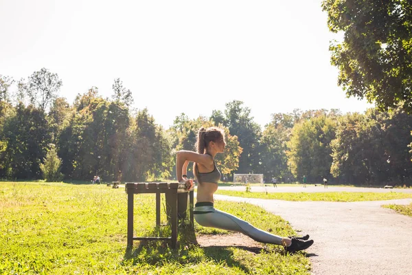 Jeune femme en forme faisant de l'exercice en faisant des pompes à l'extérieur — Photo