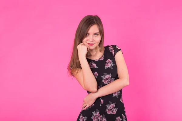 Jovem mulher em um vestido em um fundo rosa — Fotografia de Stock