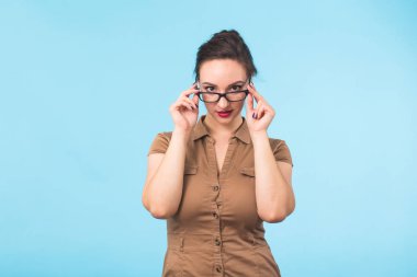 Mavi arka plan kopya alanı ile kameraya gülümseyen gözlük zarif neşeli esmer