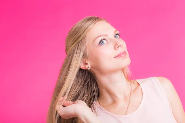 Mooi blond meisje portret met de handen voor cosmetische concept op roze achtergrond. — Stockfoto