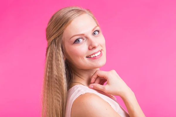 Gelukkig Blonde vrouw op roze achtergrond. Lachende mannequin met kapsel — Stockfoto