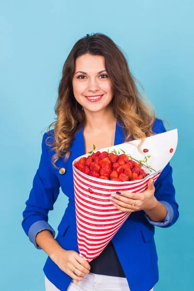 Beautiful woman holding bouquet made of strawberry