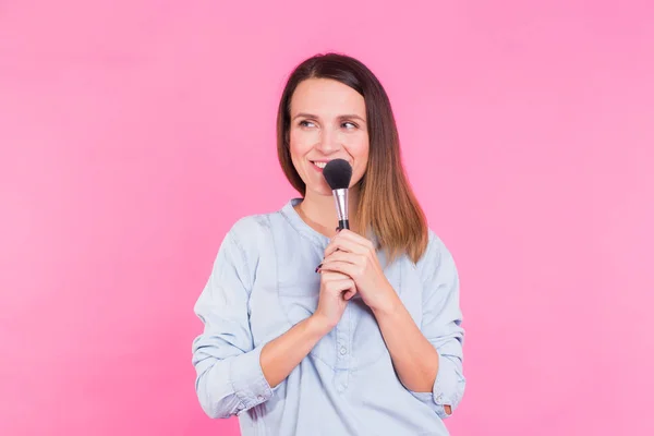 Artista de maquillaje profesional con pinceles sobre fondo rosa — Foto de Stock