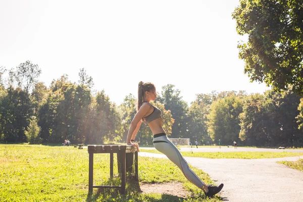 Sport, fitness, motion och livsstil koncept - kvinna gör sport utomhus. — Stockfoto