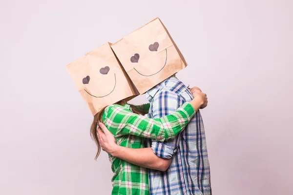 Liebespaar bedeckt sein Gesicht mit Papiertüte über weißem Hintergrund — Stockfoto