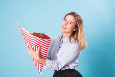 Çilek kız mavi arka plan üzerinde elinde buket