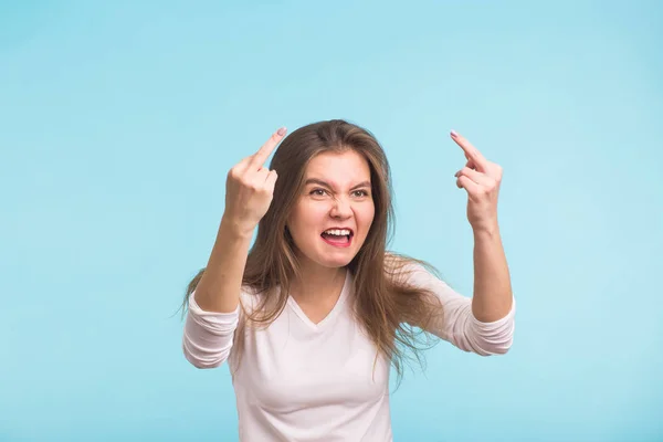 Wütende aggressive Frau mit grimmigem Gesichtsausdruck auf blauem Hintergrund — Stockfoto