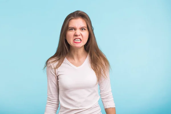 Portret van jonge boze vrouw op blauwe achtergrond — Stockfoto