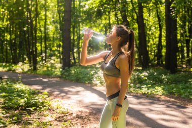 Açık havada koşu sonra genç kadın içme suyu
