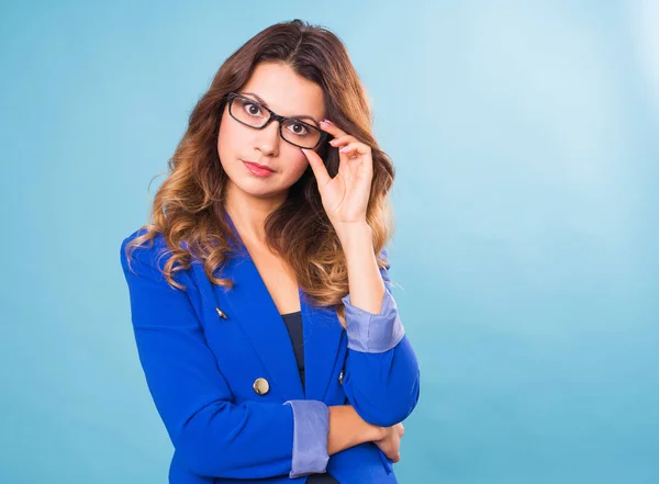 Glückliche Geschäftsfrau mit Brille, die vor blauem Hintergrund in die Kamera blickt — Stockfoto