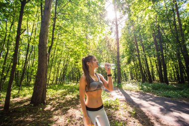 Açık havada çalıştırdıktan sonra genç kadın içme suyu