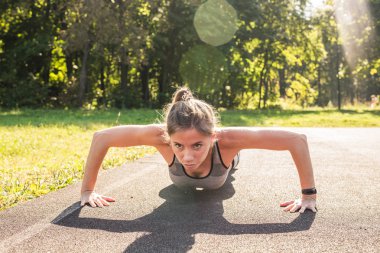 Uygun kadın parkta şınav.