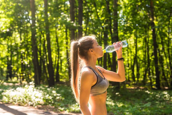 화창 한 날 옥외에서 물을 마시는 날씬 한 여자. — 스톡 사진