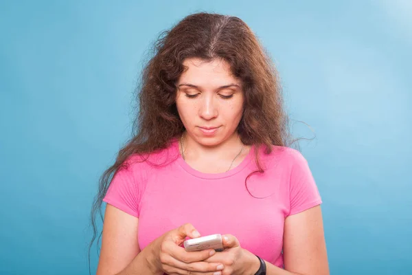 Mulher usando celular no fundo azul — Fotografia de Stock