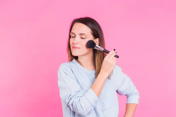 Retrato de maquillador con pincel sobre fondo rosa . — Foto de Stock
