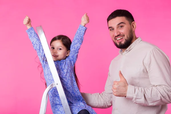 Padre y su hijita con pulgares arriba sobre fondo rosa. Hombre adulto y niña son felices — Foto de Stock
