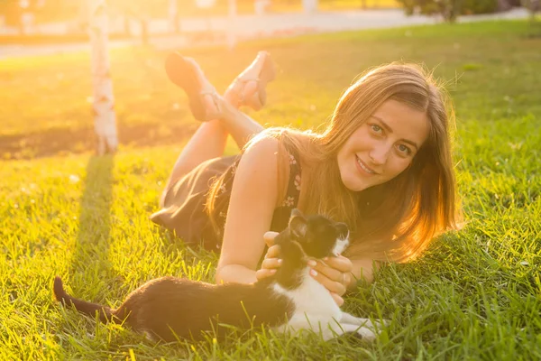 애완 동물 및 소유자 개념-소녀 고양이 잔디에서 놀고. — 스톡 사진