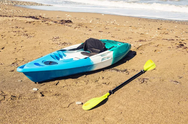 Blauwe kajak liggend op het zandstrand — Stockfoto