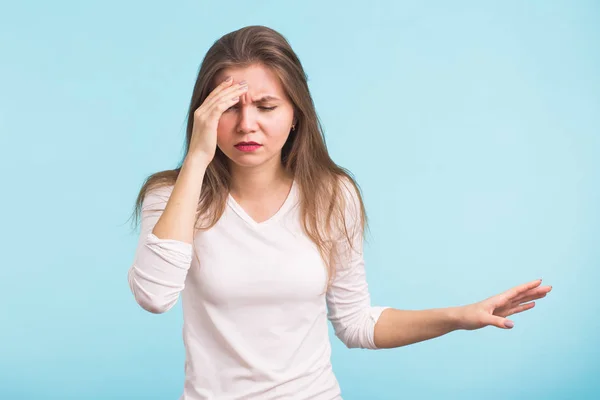 Portrait de belle jeune femme aux épaules nues touchant ses tempes se sentant stressée, sur fond bleu — Photo