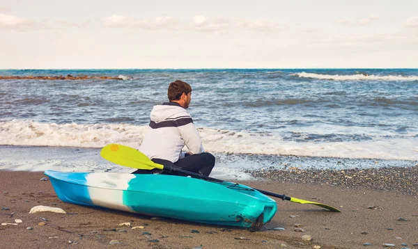 Hombre sentado en kayak en la playa del mar — Foto de Stock