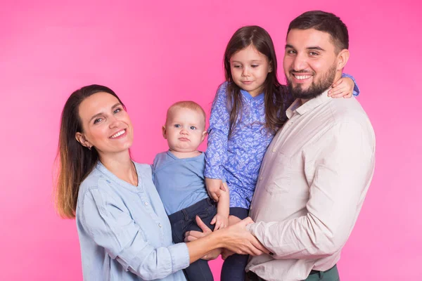 Feliz retrato familiar de raza mixta sonriendo sobre fondo rosa — Foto de Stock