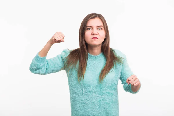 Joven morena furiosa muestra puño. La chica está muy enojada y lista para usar sus puños. Emociones agresivas negativas en su cara . — Foto de Stock