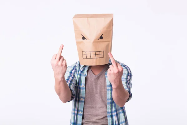 Homem com caixa de papelão na cabeça e desenho de rosto emoticon irritado. Zangado homem começando uma luta . — Fotografia de Stock