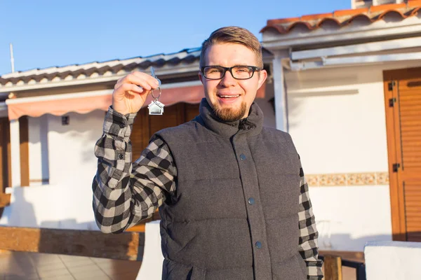 Joven hombre feliz mostrando una llave de la casa — Foto de Stock