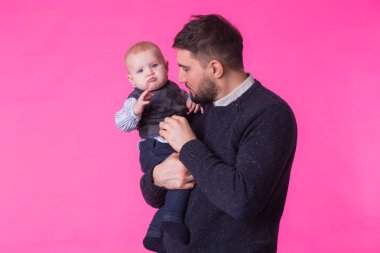 bir pembe izole bir bebek oğluyla mutlu baba