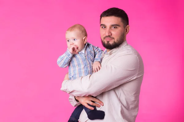 Bebé en las manos de papá. Fondo rosa . — Foto de Stock