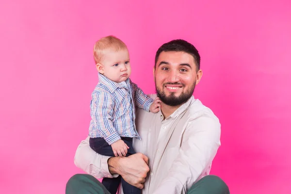 Glückliches Porträt von Vater und Sohn auf rosa Hintergrund. im Studio — Stockfoto