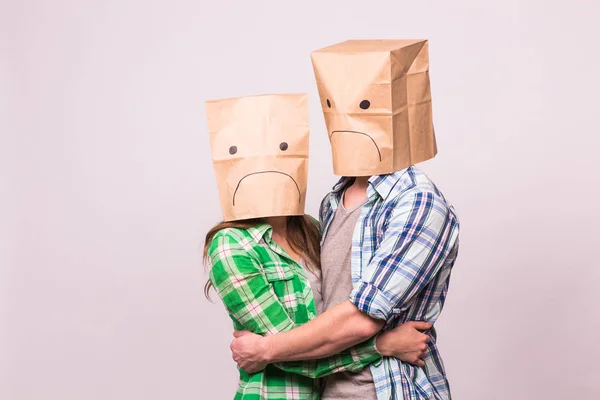 Люди, трудности в отношениях, конфликты и семейная концепция - несчастливая пара закрывает свои лица бумажным пакетом на белом фоне . — стоковое фото