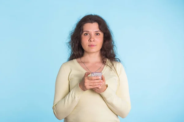 Mujer usando teléfono celular sobre fondo azul —  Fotos de Stock