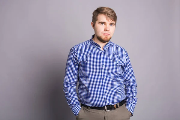 Retrato de un joven guapo triste sobre fondo gris con espacio para copiar — Foto de Stock