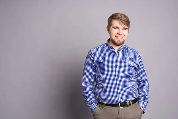 Porträt eines gutaussehenden jungen Mannes vor grauem Hintergrund mit Kopierraum — Stockfoto