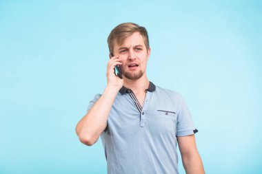 Gülümseyen adam arka plan mavi bir cep telefonu üzerinde bahsediyoruz