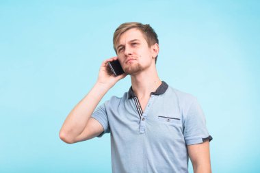 Gülümseyen adam arka plan mavi bir cep telefonu üzerinde bahsediyoruz