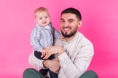 Bebek baba elinde. Pembe bir arka plan.